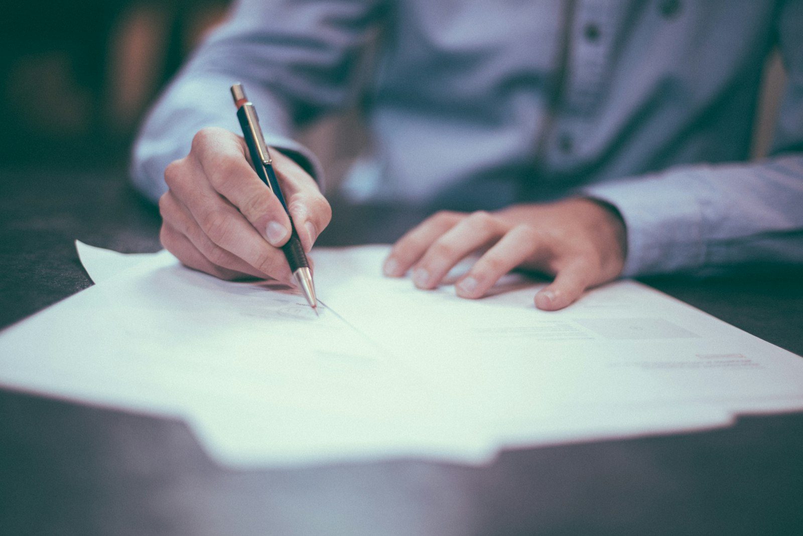 Signing property paperwork at a desk