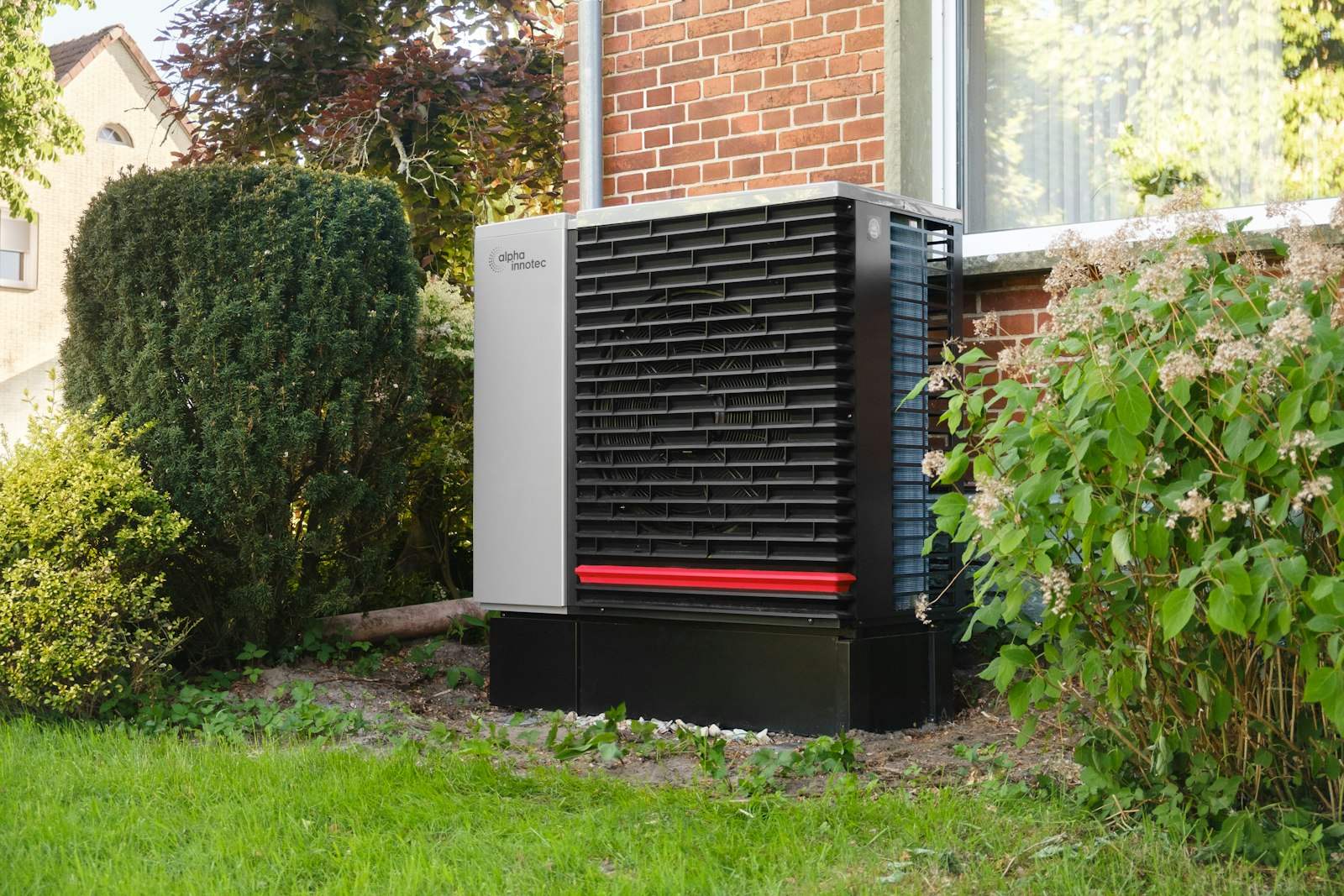 Air source heat pump outside a brick house