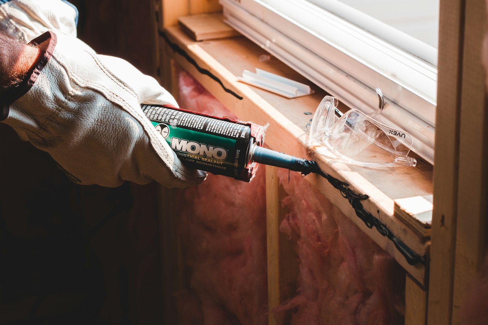 Installer sealing a window frame to reduce draughts